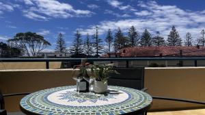 a table with two glasses and a bottle on a balcony at Ahoy Brunswick 1 in Brunswick Heads