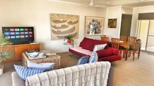 a living room with couches and a dining room at Ahoy Brunswick 1 in Brunswick Heads