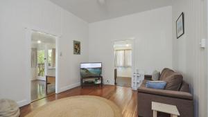 a living room with a couch and a tv at Pinchin's Place in Brunswick Heads