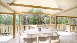 a large screened porch with a white table and chairs at MiaCasa in New Brighton