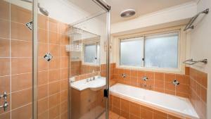 a bathroom with a tub and a sink and a shower at MiaCasa in New Brighton