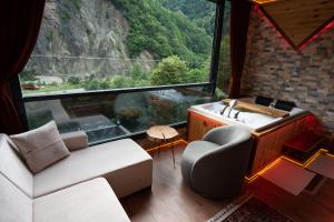 a living room with a couch and a large window at Gale Suit in Çamlıhemşin