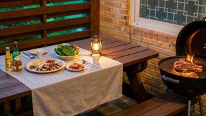 a table with two plates of food and a grill at Gapyeong Swimteo Pet Pension in Gapyeong