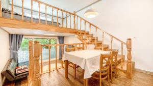 a dining room with a table and a staircase at Gapyeong Swimteo Pet Pension in Gapyeong