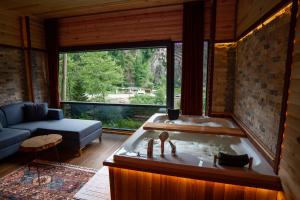 a bath tub in a room with a large window at Gale Suit in Çamlıhemşin