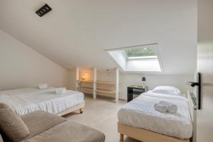 a attic bedroom with two beds and a window at Hoeve de Eik in Epen