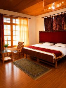 a bedroom with a large bed with a red headboard at Zotpa Hostel in Leh