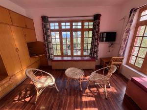 a living room with two chairs and a window at Zotpa Hostel in Leh