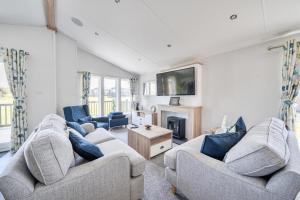 a living room with two couches and a tv at Atlantic Breeze, Mullacott Park in West Down