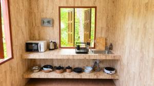 a kitchen with a counter with a microwave and a sink at Zen Village in Ko Phangan +10 photos