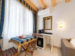 a small room with a table and a desk at FloVe' Rooms Venice in Venice
