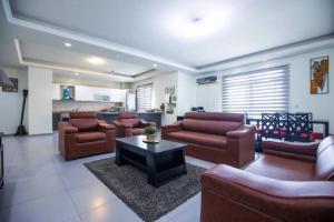 a large living room with couches and a table in it at Tcc - Skysuites in Accra