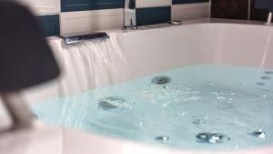 a bath tub with water coming out of it at Gapyeong Solle Spa Pension in Gapyeong