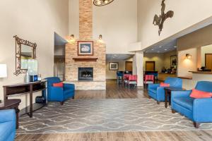 a lobby with blue chairs and a fireplace at Comfort Inn & Suites Midtown in Ruidoso