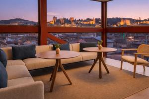 ein Wohnzimmer mit einer Couch und zwei Tischen in der Unterkunft Meliá Granada in Granada