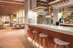 ein Restaurant mit einer Bar mit Hockern in der Unterkunft Meliá Granada in Granada + 100 Fotos