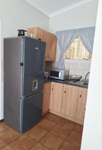 a kitchen with a stainless steel refrigerator and a microwave at Cozy Room in Ellisras