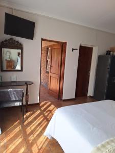 a bedroom with a bed and a table and a mirror at Cozy Room in Ellisras