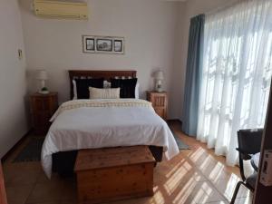 a bedroom with a bed and a large window at Cozy Room in Ellisras