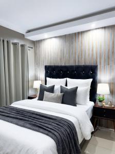 a bedroom with a large bed with a black headboard at The Seamless Oasis in Cape Town