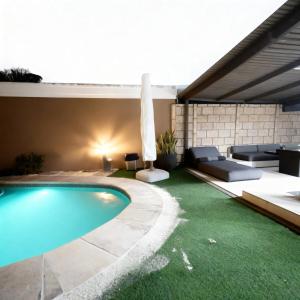 a backyard with a swimming pool and an umbrella and grass at The Seamless Oasis in Cape Town