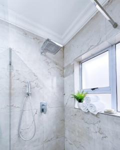 a bathroom with a shower with a window and a sink at The Seamless Oasis in Cape Town +11 photos