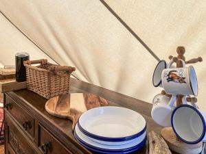 a table with a mirror and some plates on it at The Belle Tent in Otterburn