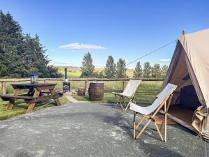 a tent and two chairs and a picnic table and a table at The Belle Tent in Otterburn