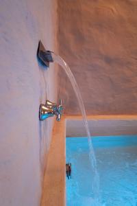 a water fountain next to a swimming pool at vabè apulian accommodation in Ostuni