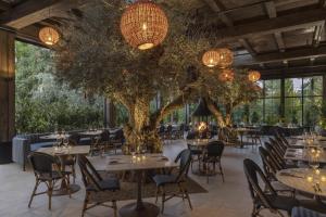 a restaurant with tables and chairs and a large tree at Casa Mani Resort Napa Valley, Curio Collection By Hilton in Napa