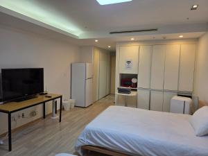 a bedroom with a bed and a desk and a television at Incheon Airport Yeongjong Guesthouse in Incheon +13 photos