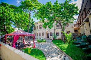 a garden with a gazebo in front of a building at Cathedral Hotel Zanzibar in Zanzibar City