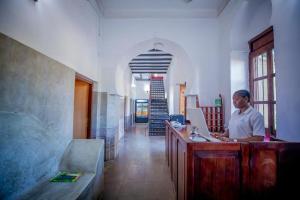 a woman sitting at a desk with a laptop at Cathedral Hotel Zanzibar in Zanzibar City