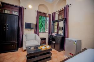 a living room with a chair and a desk at Cathedral Hotel Zanzibar in Zanzibar City