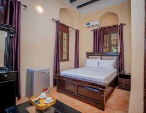 a bedroom with a bed and a tv in it at Cathedral Hotel Zanzibar in Zanzibar City +85 photos