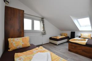 a attic room with two beds and a window at Penzión Štrba in Štrbské Pleso