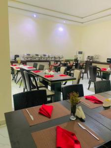 a dining room with tables and chairs with red napkins at Corporate Residence in Port Harcourt +9 photos