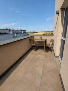 a patio with a table and chairs on a balcony at MarchfeldStay in Gänserndorf