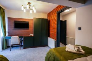 a bedroom with a bed and a desk with a television at Aurelius Hotel & Restaurant in Pljevlja