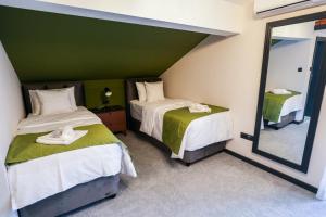 a bedroom with two beds and a mirror at Aurelius Hotel & Restaurant in Pljevlja +16 photos