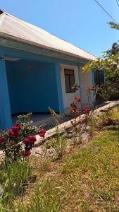 a blue house with flowers in front of it at Shalom Homestay in Kilindoni