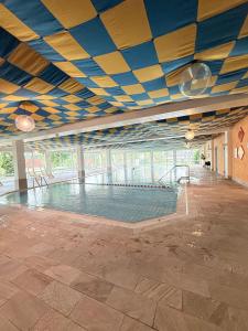 an empty swimming pool with a blue and yellow ceiling at AlpinLounge Scheidegg - Studio mit Wellness und Bergblick in Scheidegg