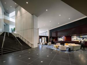 a lobby of a building with stairs and chairs at Sofitel Chicago Magnificent Mile in Chicago