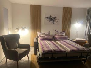 a bedroom with a bed and a chair at Ferienwohnung Fein in Bad Sachsa