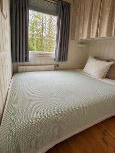 a large bed in a room with a window at Hjartarstaðir Private Country Retreat with Hot Tub in Hagi