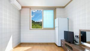 a room with a refrigerator and a window at Samcheok Eoulim Pension in Samcheok