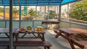 a room with benches and tables with food on it at Samcheok Eoulim Pension in Samcheok