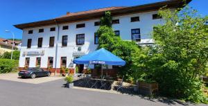a blue umbrella in front of a building at Hotel & Restaurant Klosterschänke in Ruhla