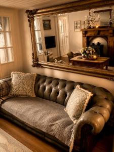 a leather couch in a living room with a mirror at Donegal Cottage in Inver