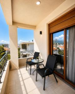 a balcony with two chairs and a table on a balcony at Arbneshi Apartments in Ulcinj
